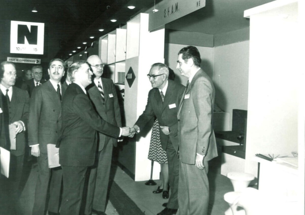 Dirigeants en costume se saluant lors d’un événement institutionnel.